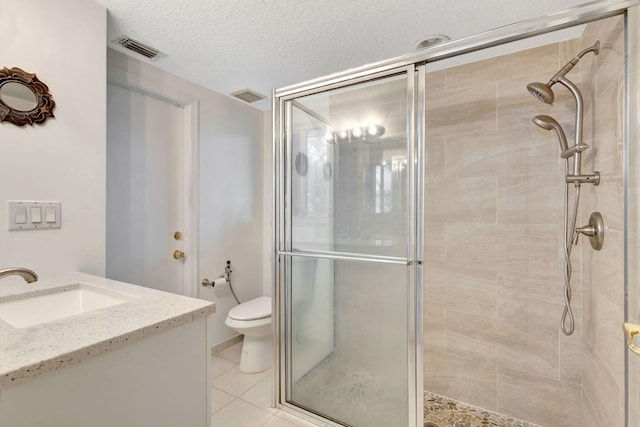 bathroom featuring a textured ceiling, tile patterned floors, vanity, toilet, and a shower with shower door