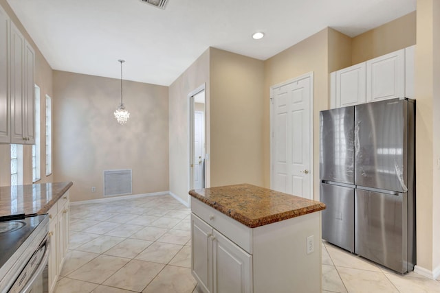 kitchen featuring electric range, stainless steel refrigerator, white cabinetry, and a kitchen island