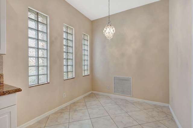 unfurnished dining area featuring a wealth of natural light, light tile patterned floors, and a notable chandelier