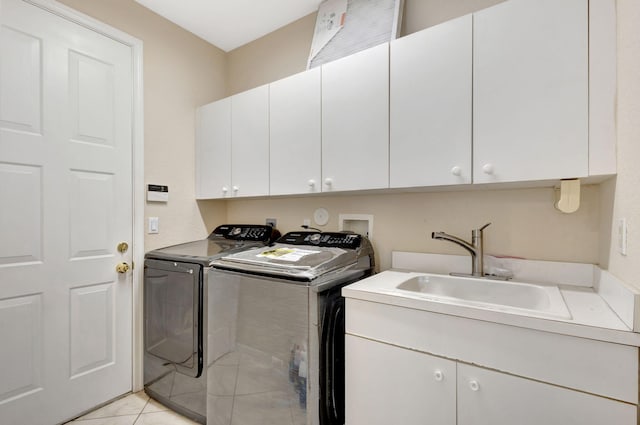 laundry area featuring cabinets, light tile patterned flooring, independent washer and dryer, and sink