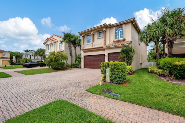 mediterranean / spanish-style home featuring a front yard and a garage