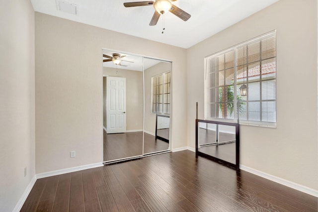 empty room with ceiling fan and dark wood-type flooring