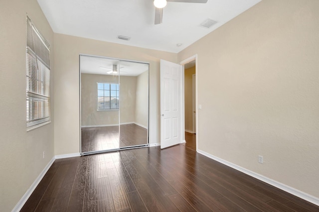 unfurnished bedroom featuring ceiling fan, dark hardwood / wood-style flooring, and a closet