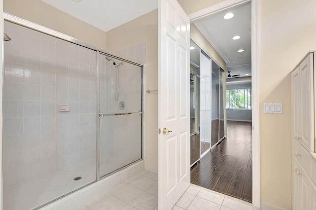 bathroom with ceiling fan, tile patterned floors, walk in shower, and ornamental molding