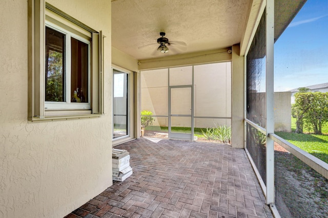 unfurnished sunroom featuring ceiling fan