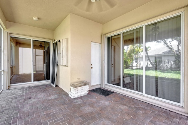 unfurnished sunroom with ceiling fan