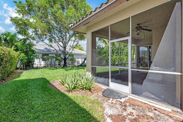 view of yard with ceiling fan and a sunroom