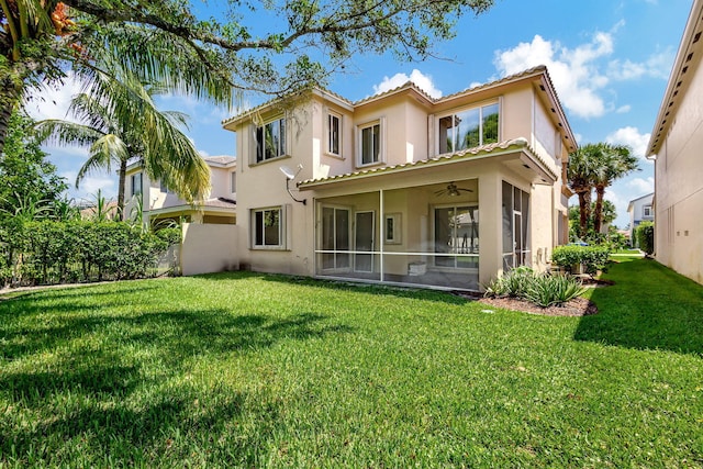 rear view of property featuring a lawn and a sunroom