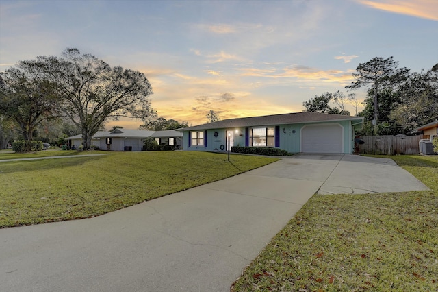 single story home featuring a yard and a garage