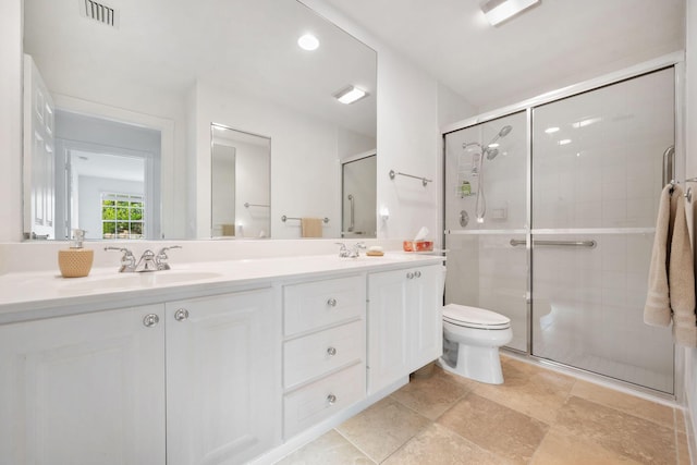 bathroom with vanity, a shower with shower door, and toilet