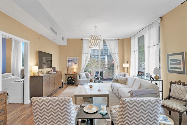 living room with a notable chandelier and light hardwood / wood-style floors