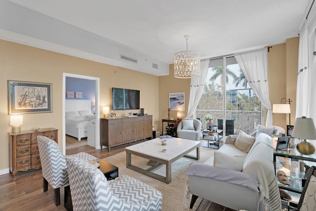 living room with an inviting chandelier and light wood-type flooring