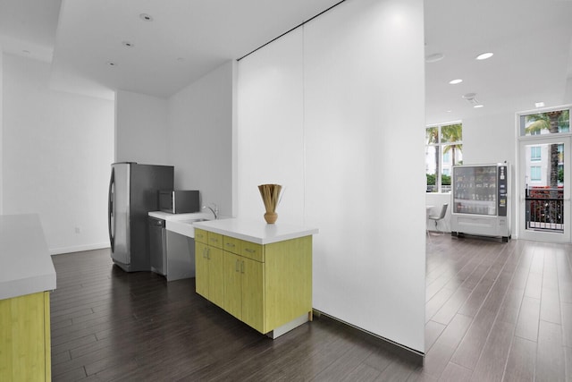 kitchen with dark wood-type flooring, a wall of windows, stainless steel appliances, and sink