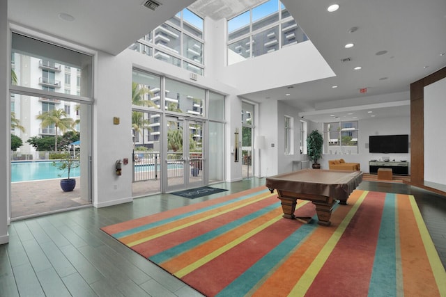 rec room with dark hardwood / wood-style floors, pool table, plenty of natural light, and french doors