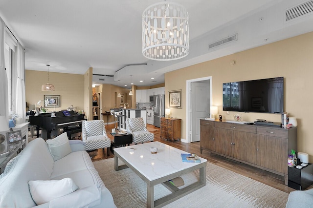 living room featuring a notable chandelier and light hardwood / wood-style flooring