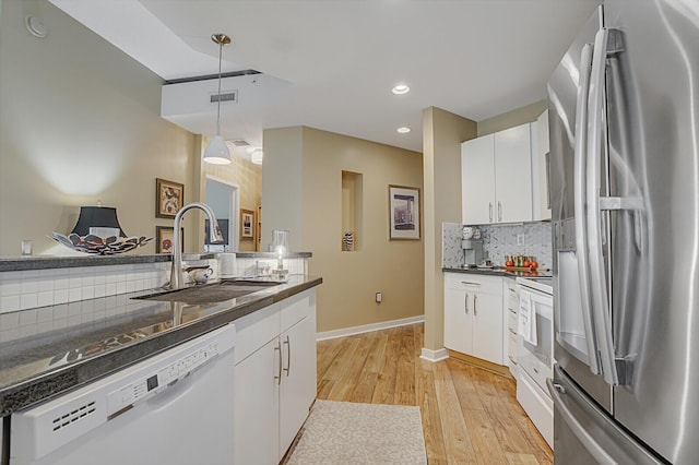 kitchen with sink, stainless steel fridge, white dishwasher, pendant lighting, and white cabinets