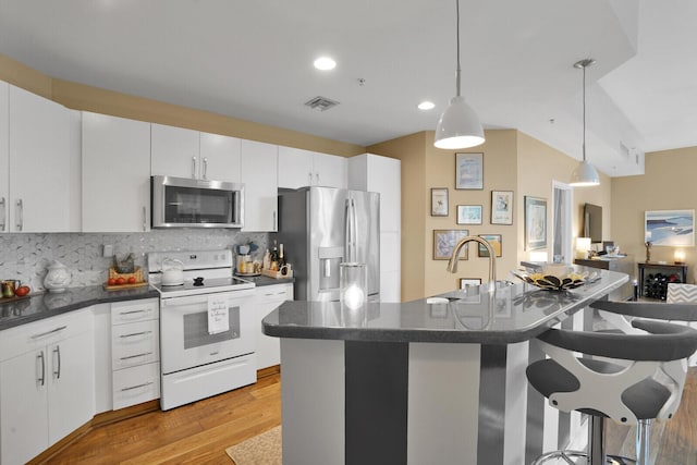 kitchen featuring hanging light fixtures, appliances with stainless steel finishes, white cabinets, and decorative backsplash