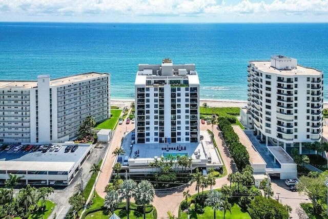 birds eye view of property featuring a water view and a beach view