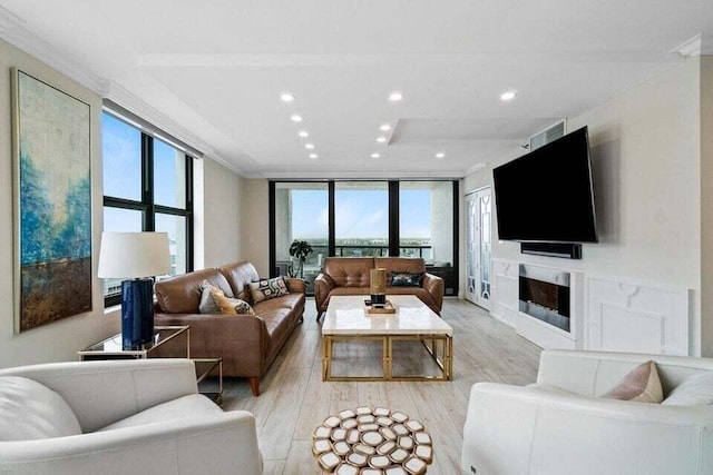 living room with expansive windows, ornamental molding, and light hardwood / wood-style flooring