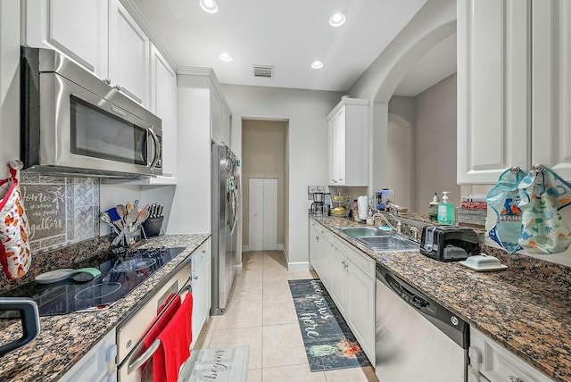 kitchen with sink, white cabinetry, light tile patterned floors, and stainless steel appliances