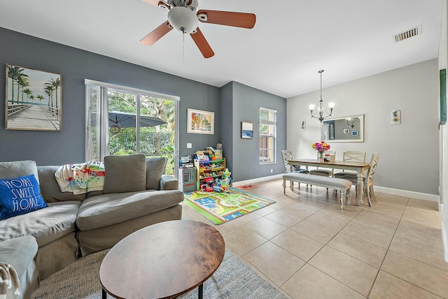 tiled living room featuring ceiling fan with notable chandelier