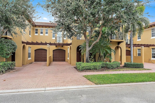 mediterranean / spanish-style house with a garage and a balcony