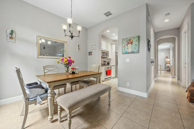 dining space with an inviting chandelier and light tile patterned flooring