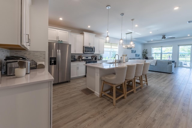 kitchen with ceiling fan, white cabinetry, light hardwood / wood-style flooring, and stainless steel appliances