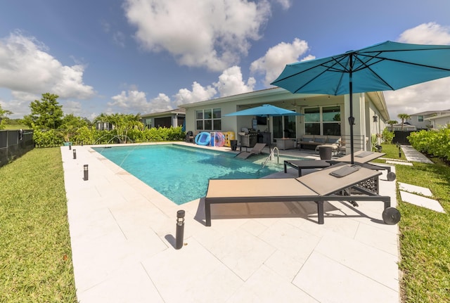 view of pool with a lawn, an outdoor living space, and a patio