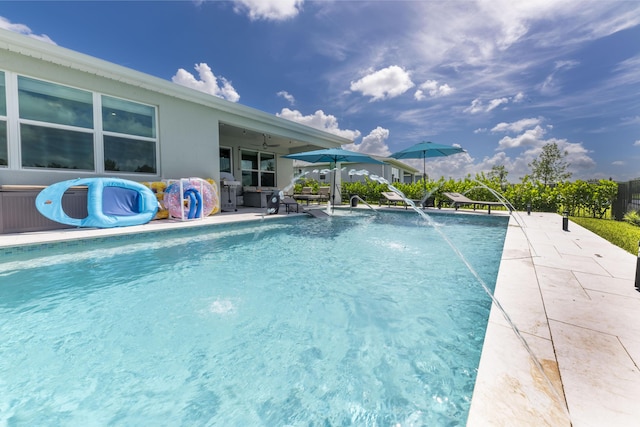 view of pool with a patio area, a grill, and pool water feature