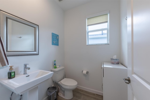 bathroom with toilet, hardwood / wood-style flooring, and sink