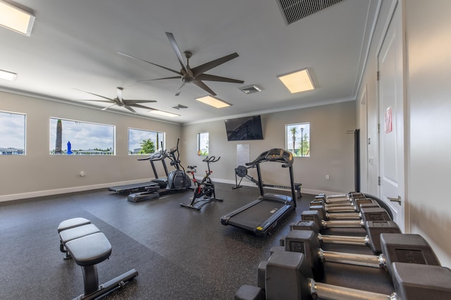 gym with ceiling fan, a wealth of natural light, and ornamental molding