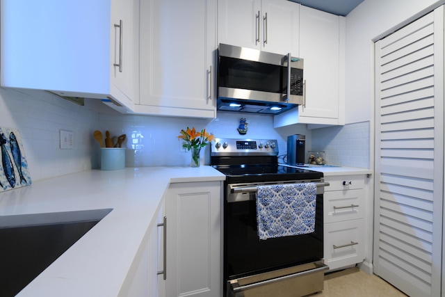 kitchen with decorative backsplash, appliances with stainless steel finishes, and white cabinetry