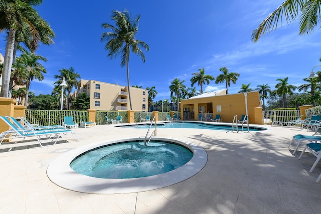 view of swimming pool featuring a community hot tub and a patio area