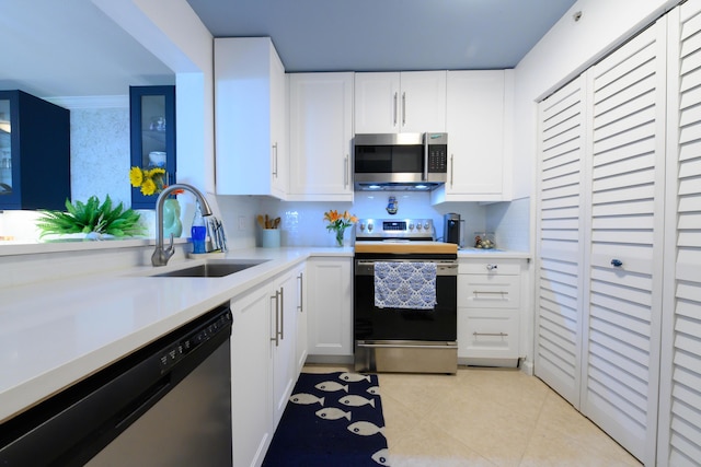 kitchen with white cabinets, sink, stainless steel appliances, and light tile patterned flooring