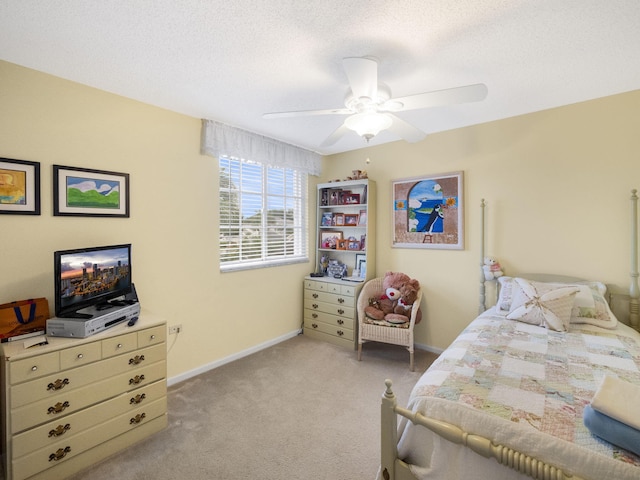 carpeted bedroom featuring ceiling fan and a textured ceiling