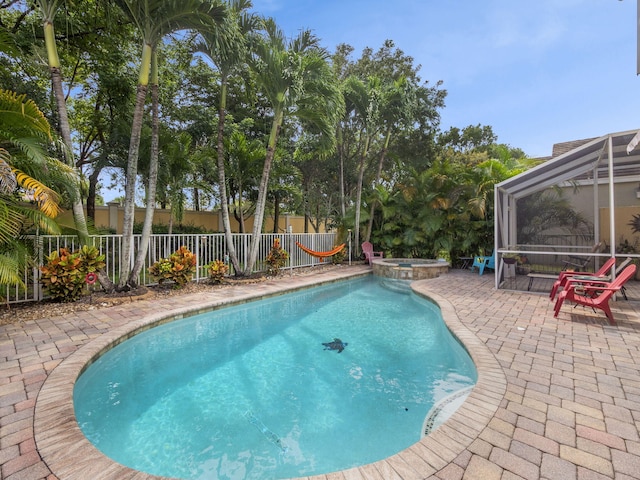 view of swimming pool with an in ground hot tub, a lanai, and a patio