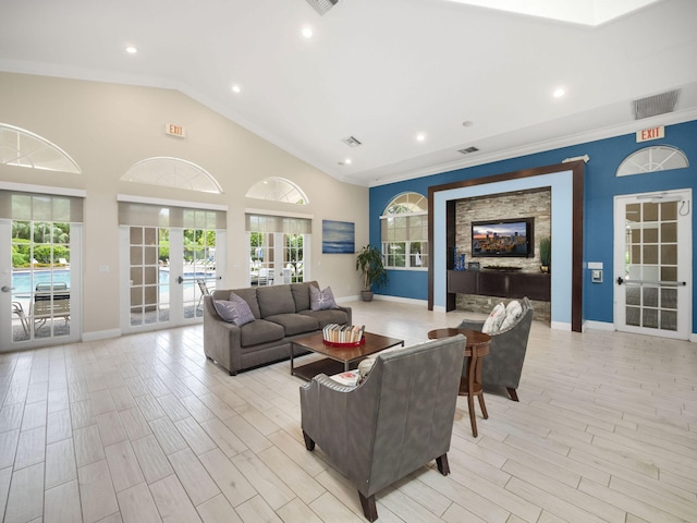 living room with plenty of natural light, ornamental molding, french doors, and vaulted ceiling