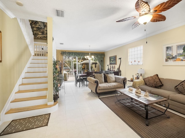 living room featuring ceiling fan with notable chandelier, a textured ceiling, and ornamental molding