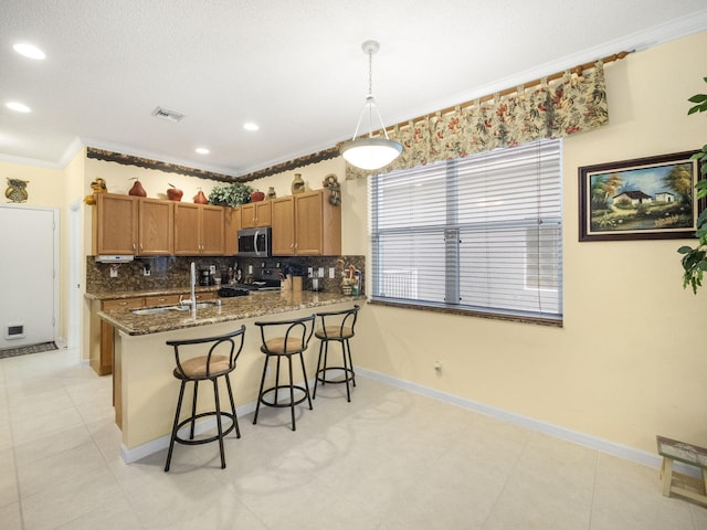 kitchen with kitchen peninsula, pendant lighting, ornamental molding, black stove, and sink