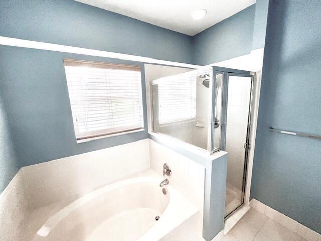 bathroom with independent shower and bath and tile patterned flooring