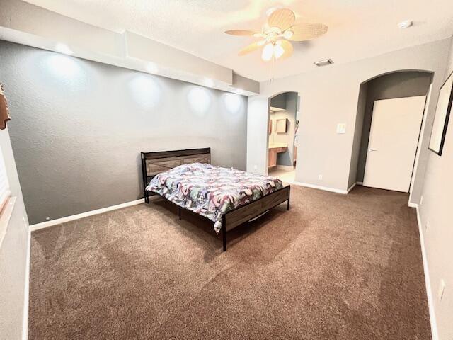 bedroom with ceiling fan and dark colored carpet