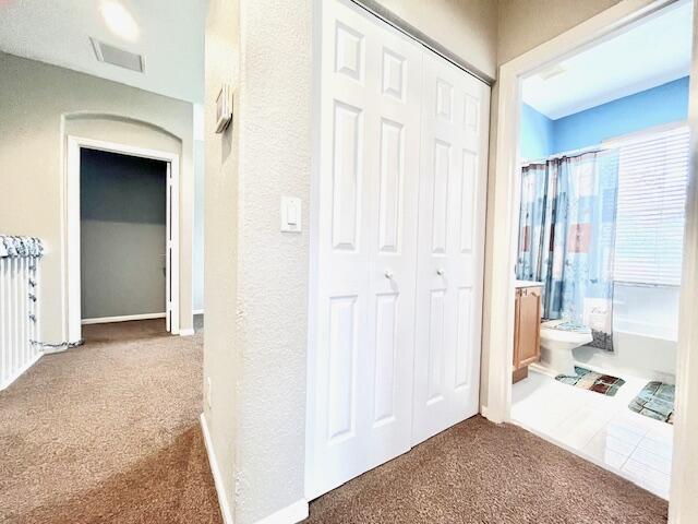 corridor featuring dark colored carpet