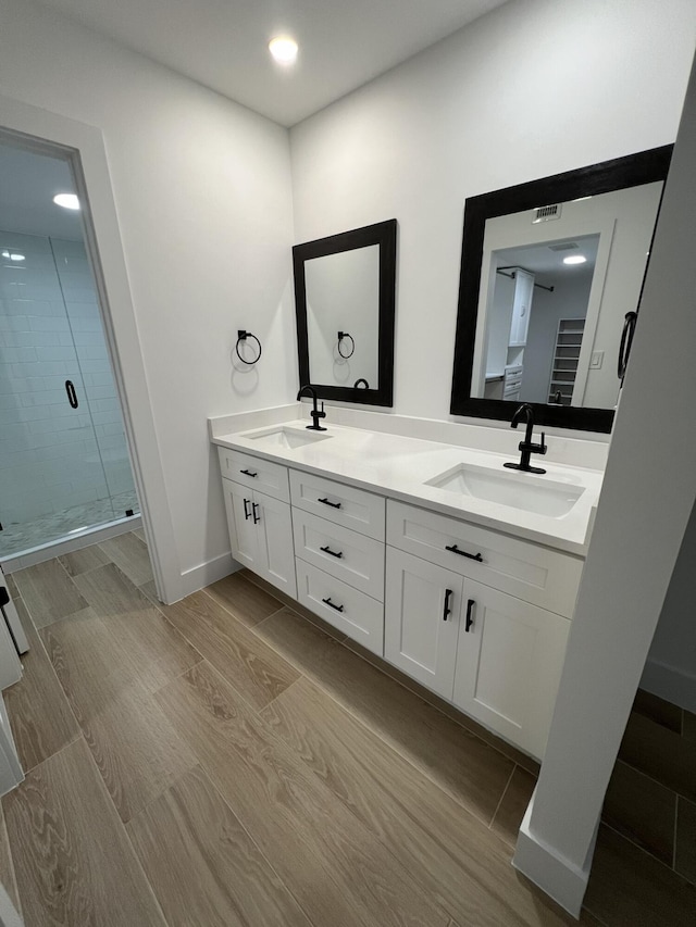 bathroom featuring walk in shower and vanity