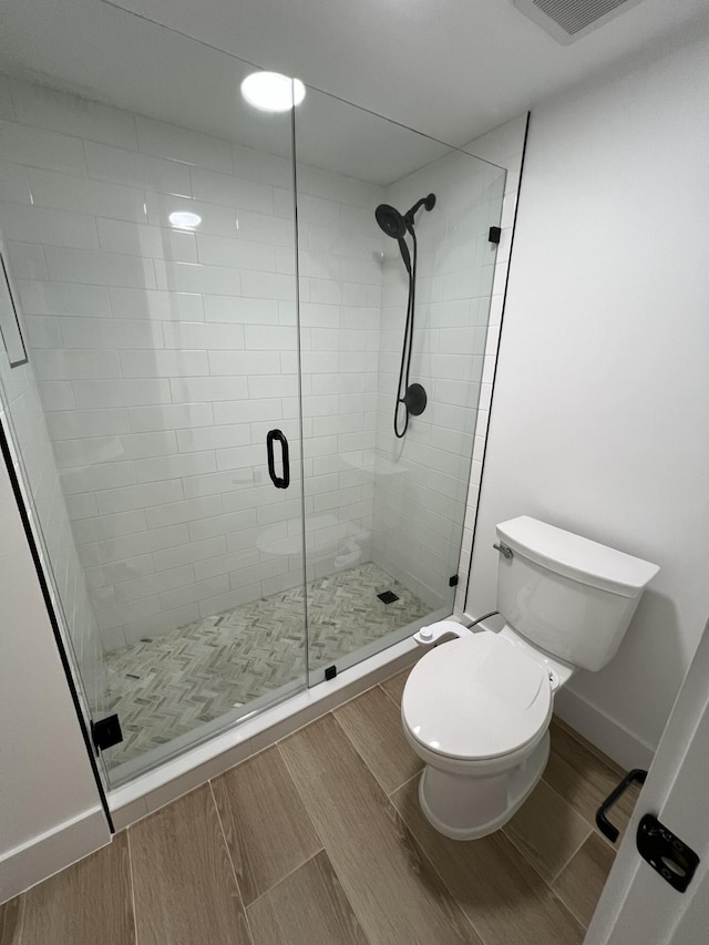 bathroom with toilet and an enclosed shower