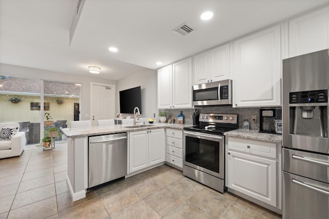 kitchen with stainless steel appliances, white cabinetry, and sink