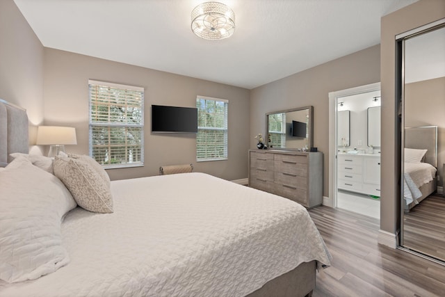 bedroom with ensuite bath and hardwood / wood-style flooring