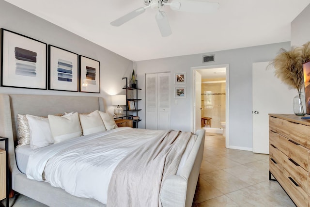 tiled bedroom featuring ceiling fan, a closet, and ensuite bath