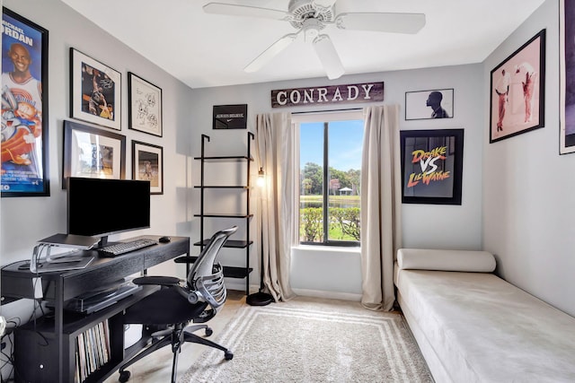 carpeted home office featuring ceiling fan