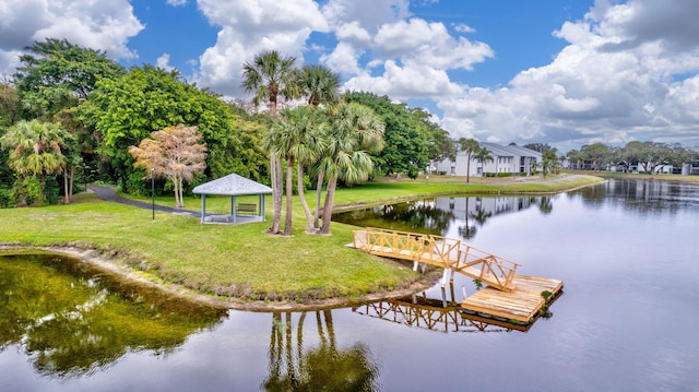 dock area with a gazebo, a yard, and a water view